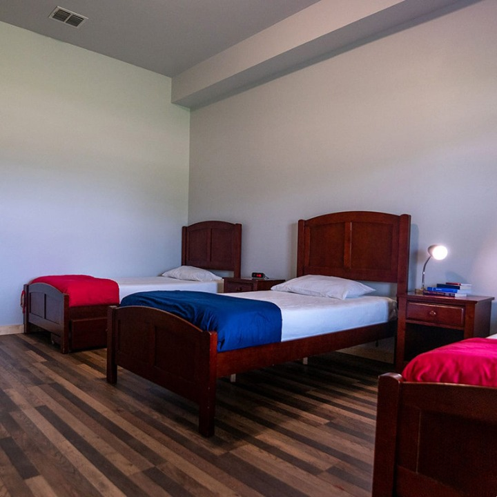 Room with three twin beds and wooden headboards