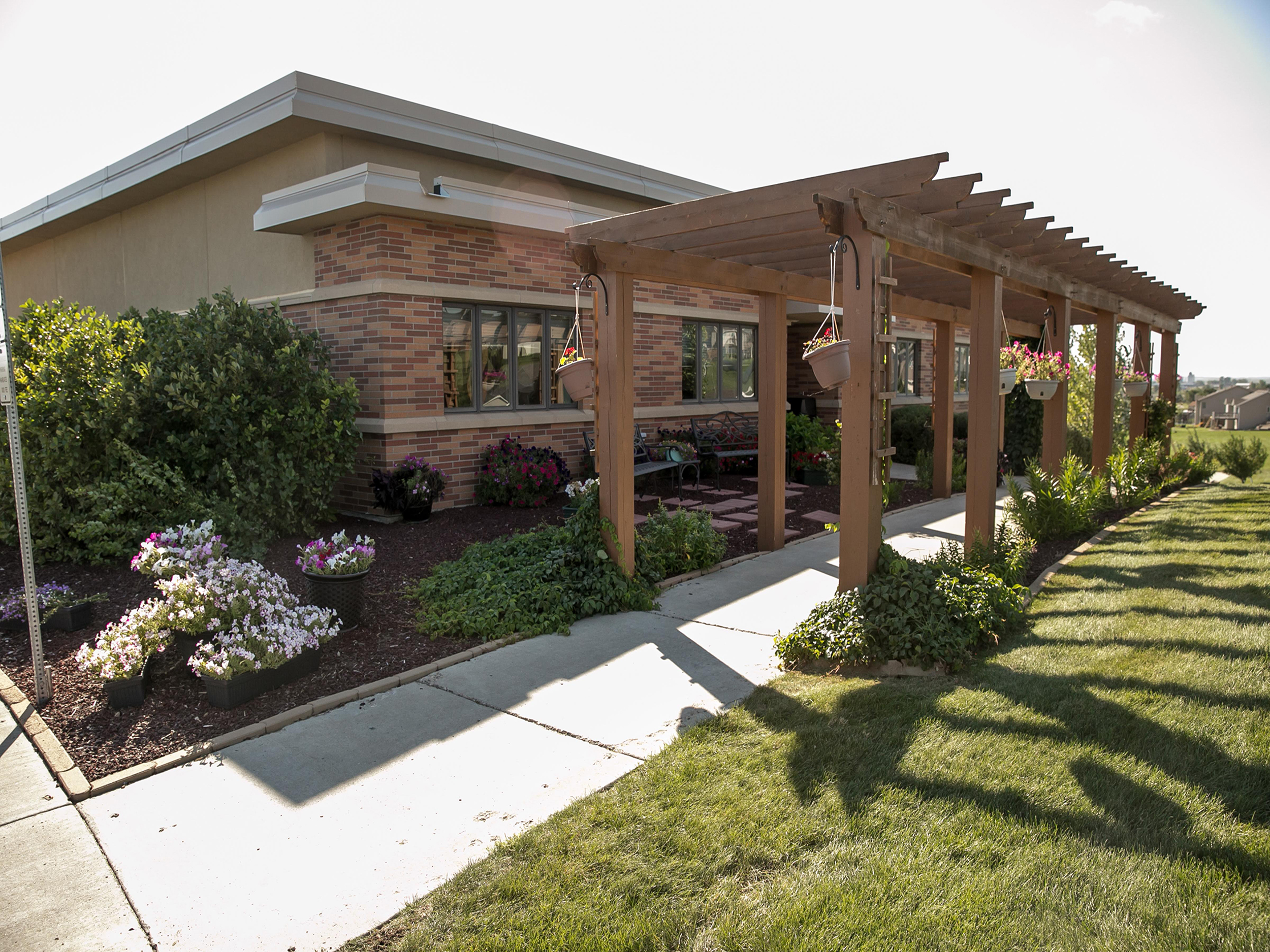 Outdoor pergola with benches and hanging flower baskets