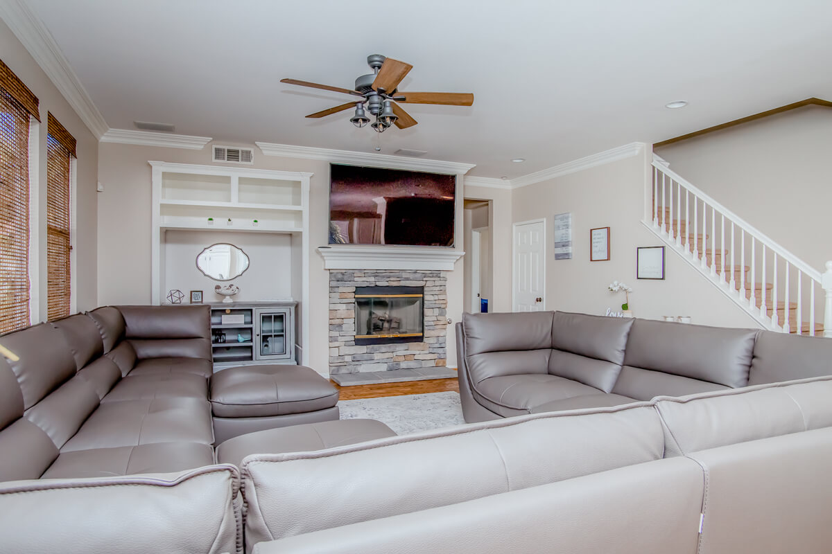 Lounge with gray leather sectional sofas and a stone fireplace
