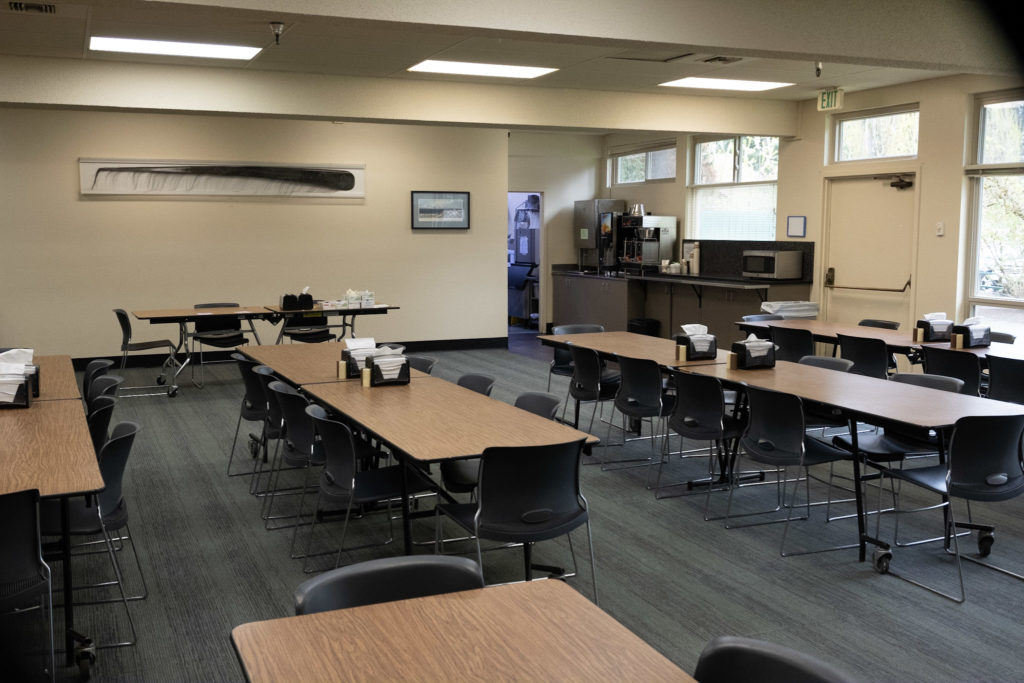 Rehab facility cafeteria with tables and kitchenette area