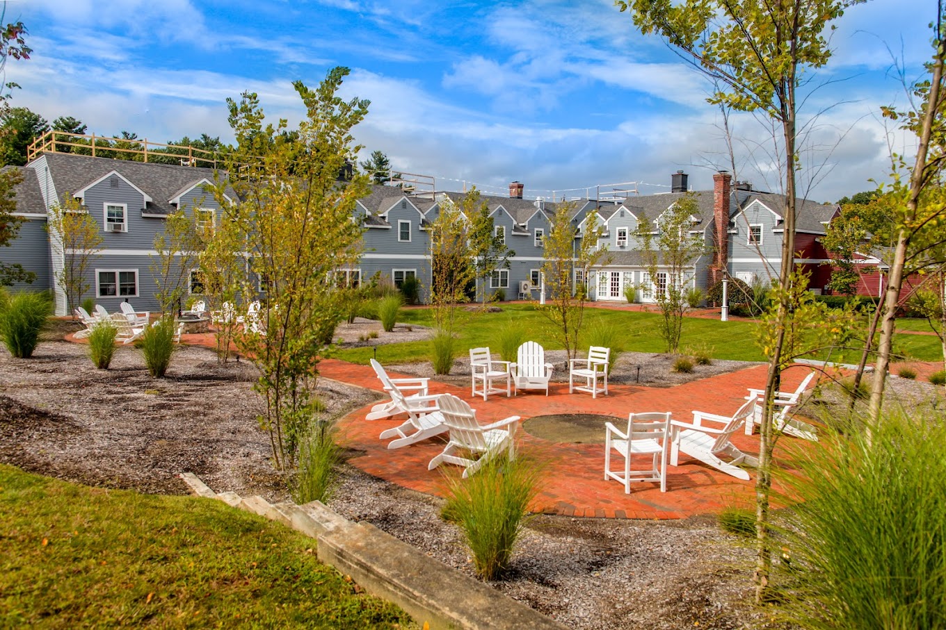 Outdoor space with chairs arranged around a fire pit.