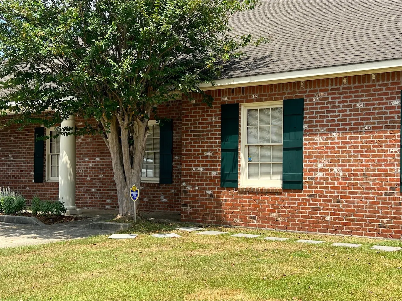 Rehab facility exterior with covered seating and green lawn