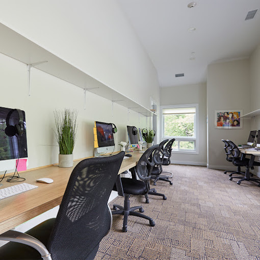 Workspace with chairs, desks, and computers.