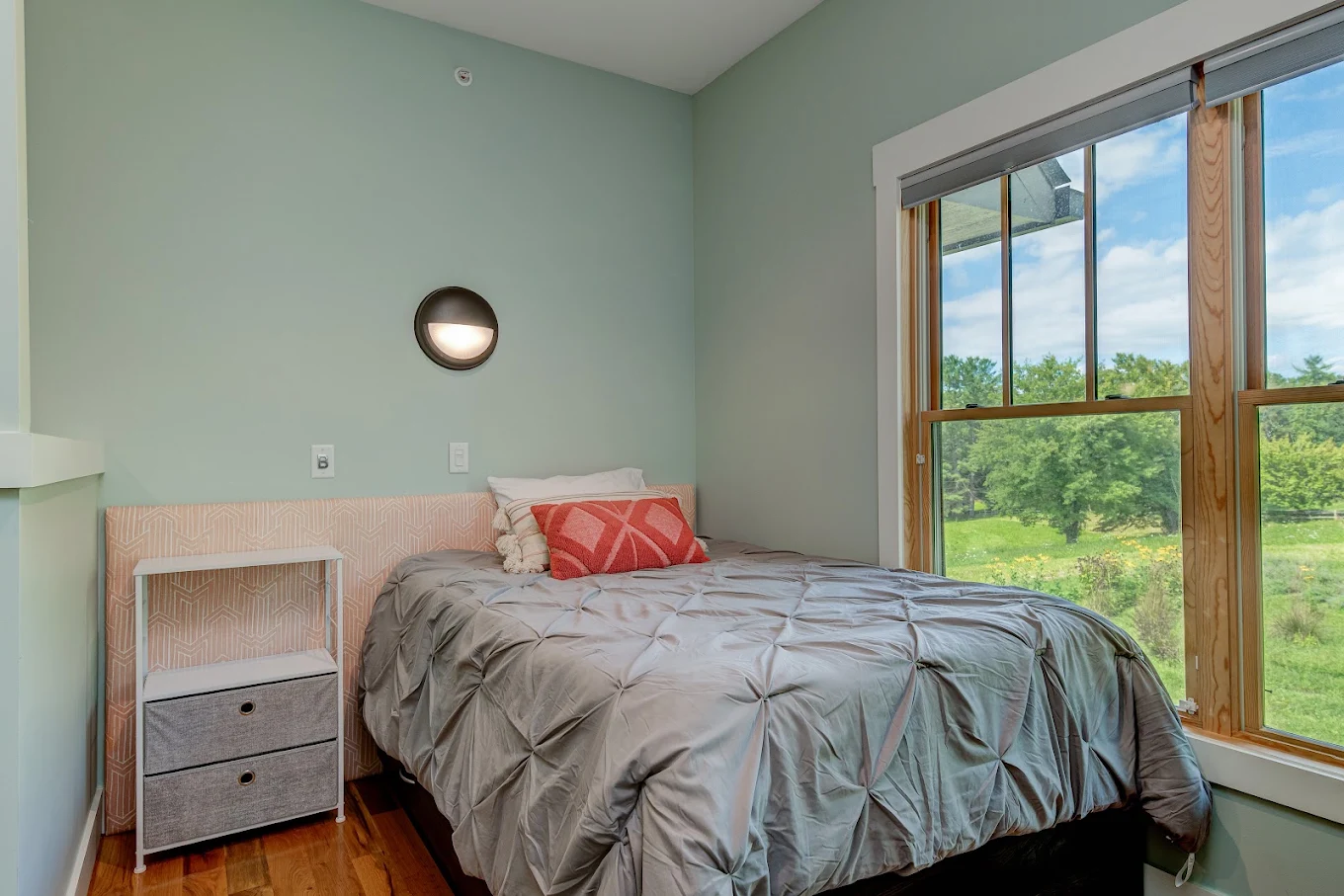 Private bedroom with large windows overlooking green grounds