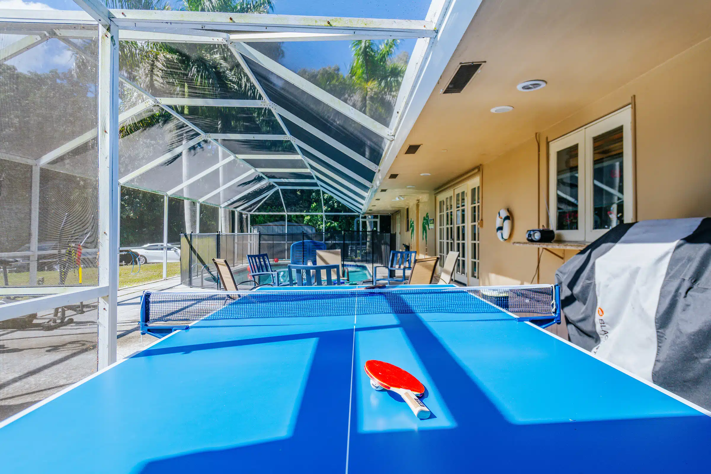Outdoor ping pong table beside pool seating area