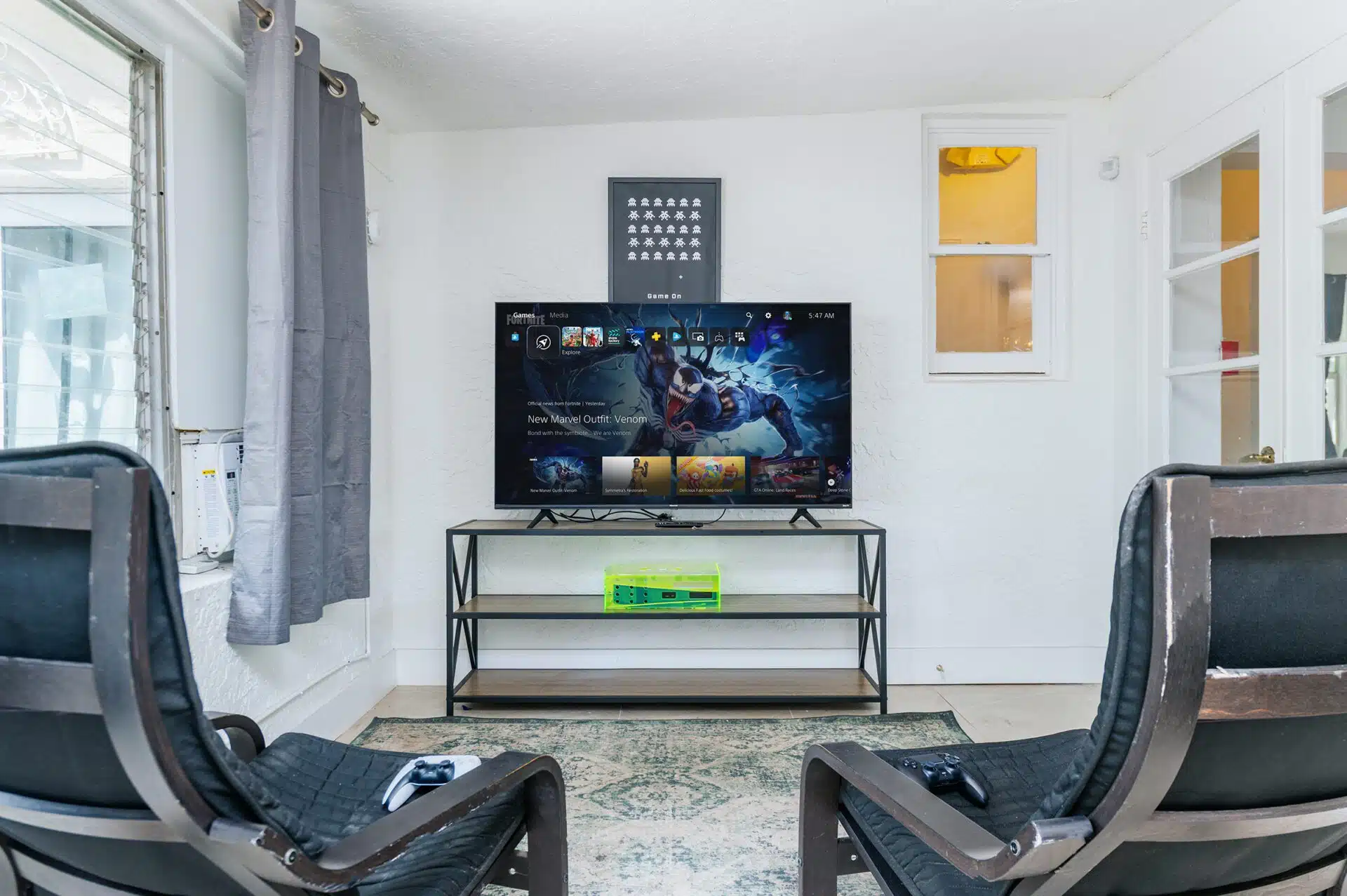 TV gaming setup with two chairs and controllers on a rug