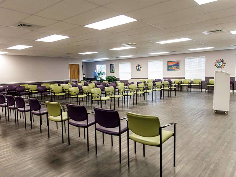 Large room with chairs arranged for group therapy