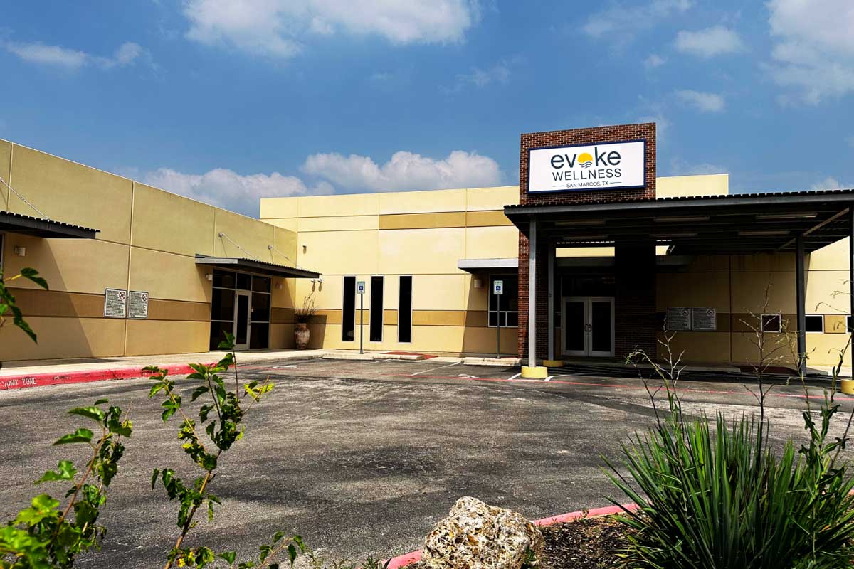Wide view of the Evoke Wellness San Marcos building exterior with accessible parking and entrance canopy