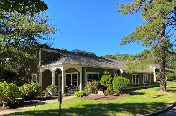 The exterior of a rehab center surrounded by greenery and landscaping.