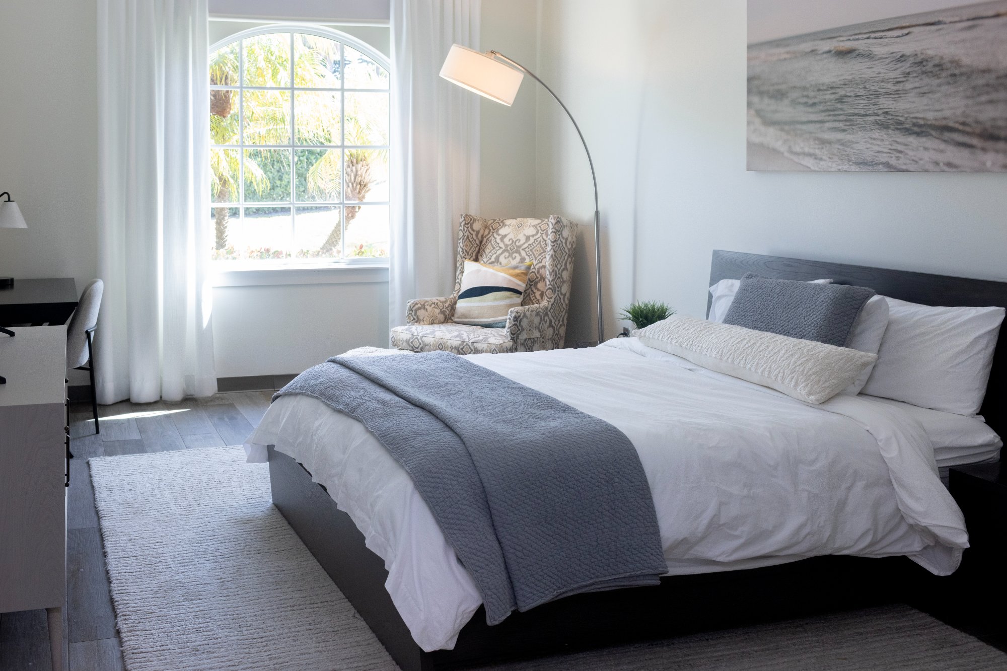 Bright private bedroom with bed and large window