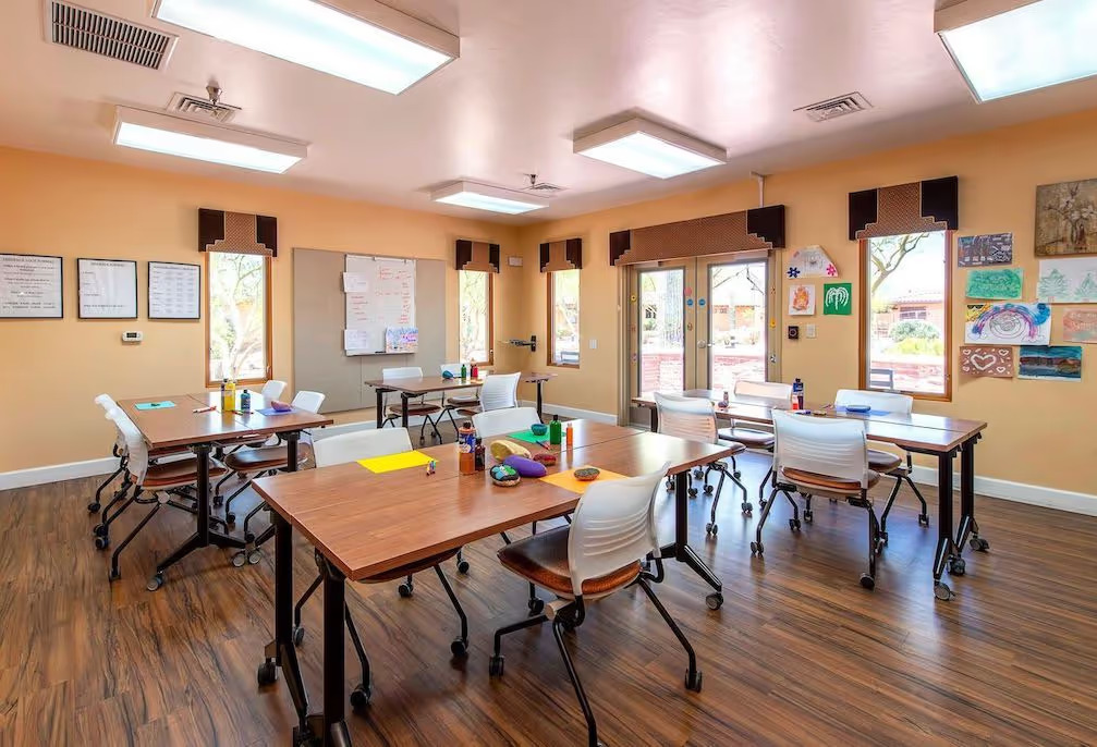 Art classroom with tables, supplies, and bright wall art