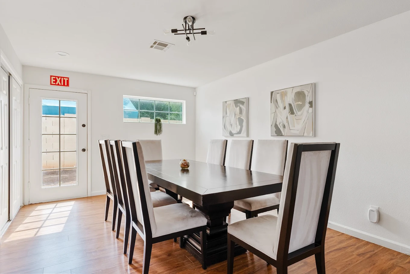 Dining room with large table, high-back chairs, and patio door