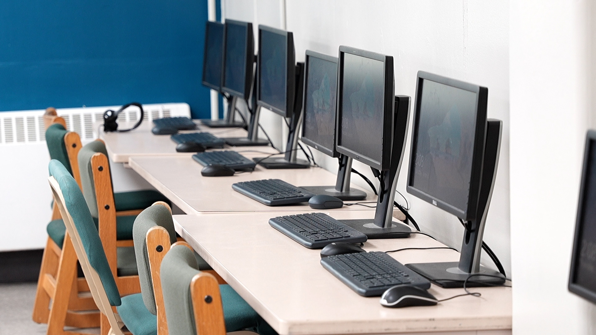 Computer lab with multiple desktops and chairs in a row