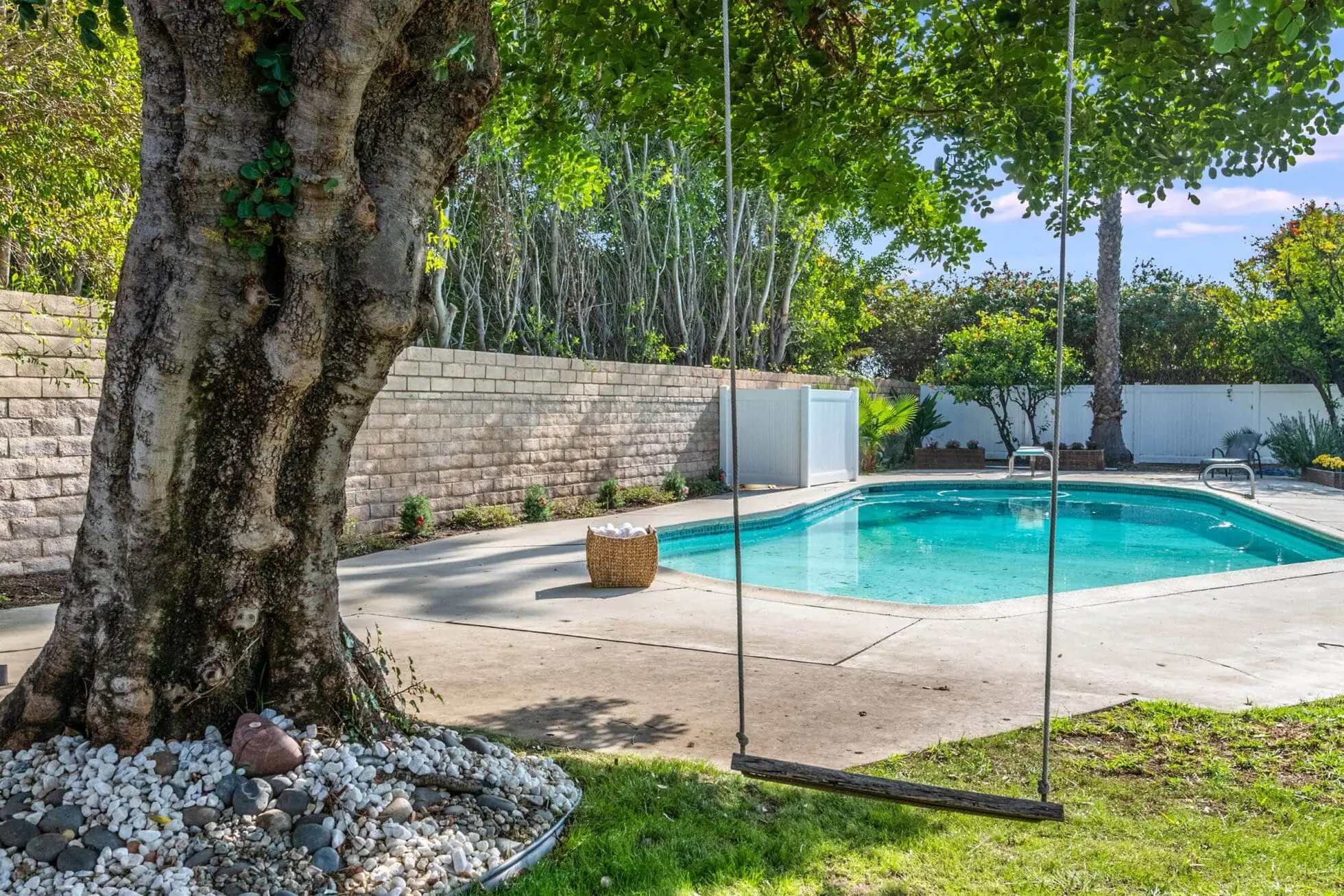 Pool near tree swing and garden wall