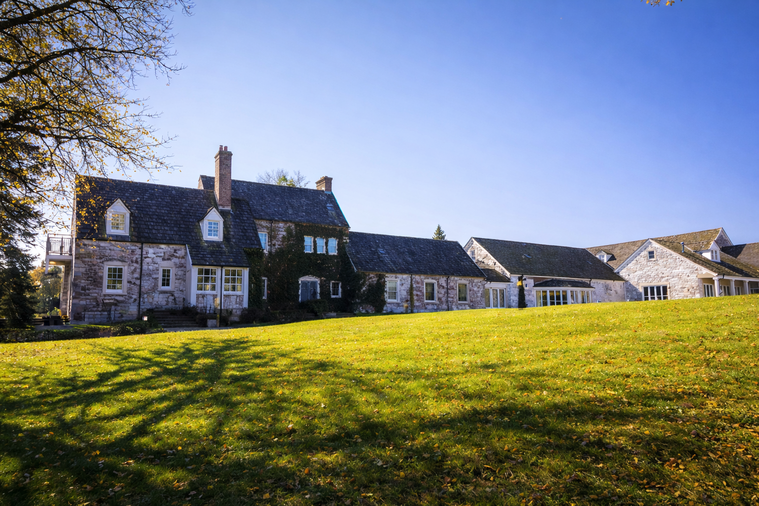 Stone residential building on a grassy hillside.