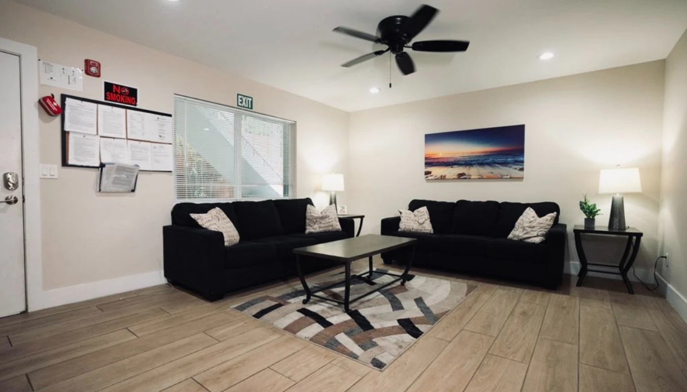 Comfortable lounge with dark sofas and a modern coffee table.