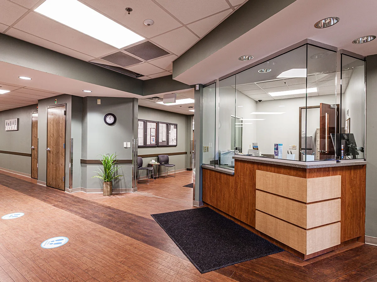 Front desk with glass barrier in clinic lobby