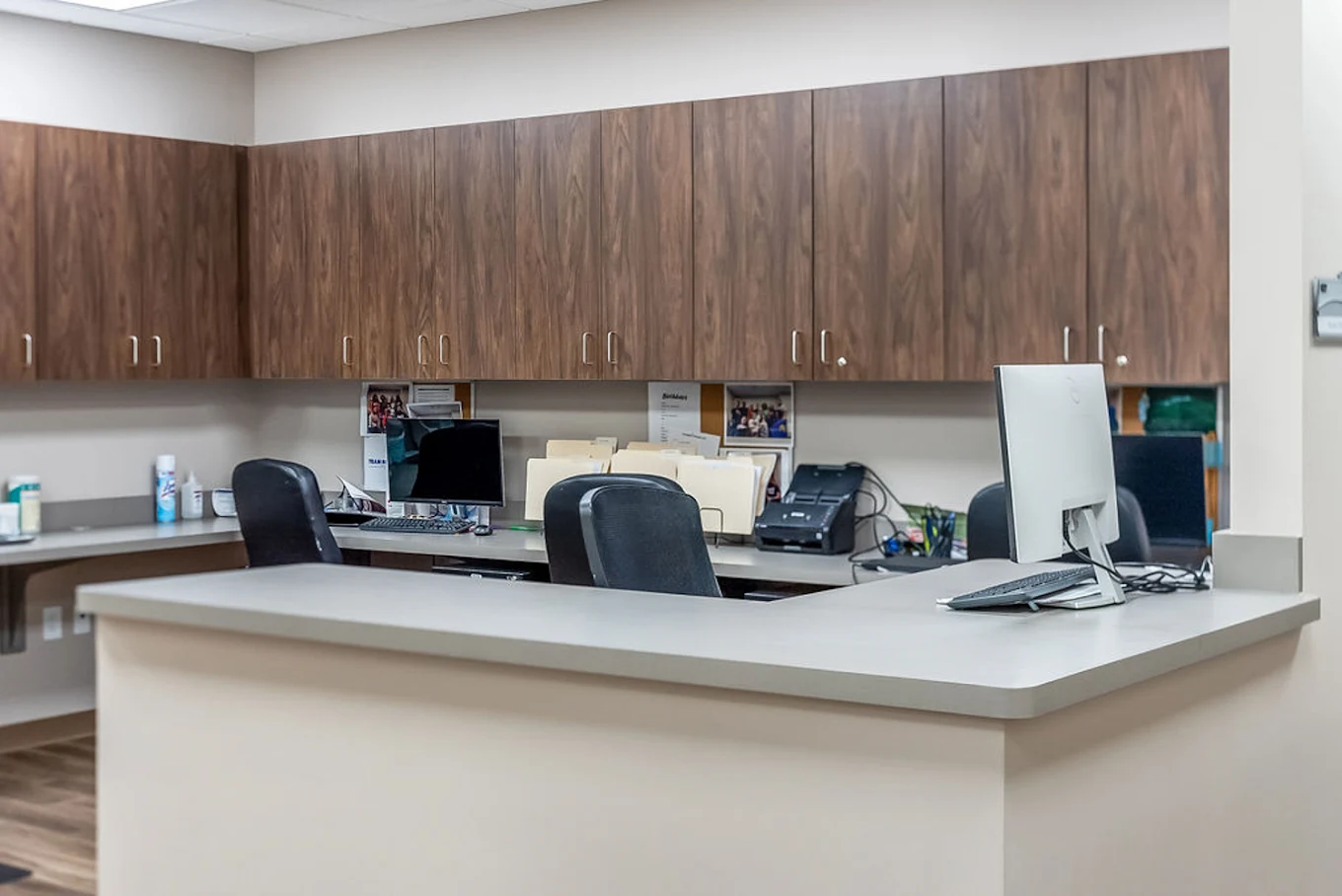 BrightView Health nurses station with reception counter, computers, office chairs, filing equipment, and wood cabinets