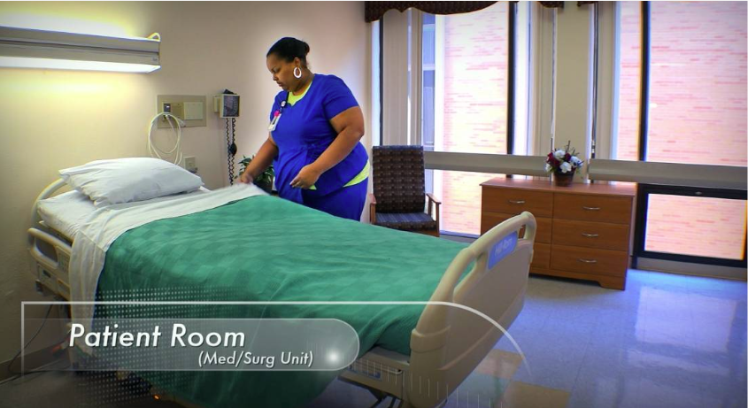 Patient bed beside large windows and wood dresser