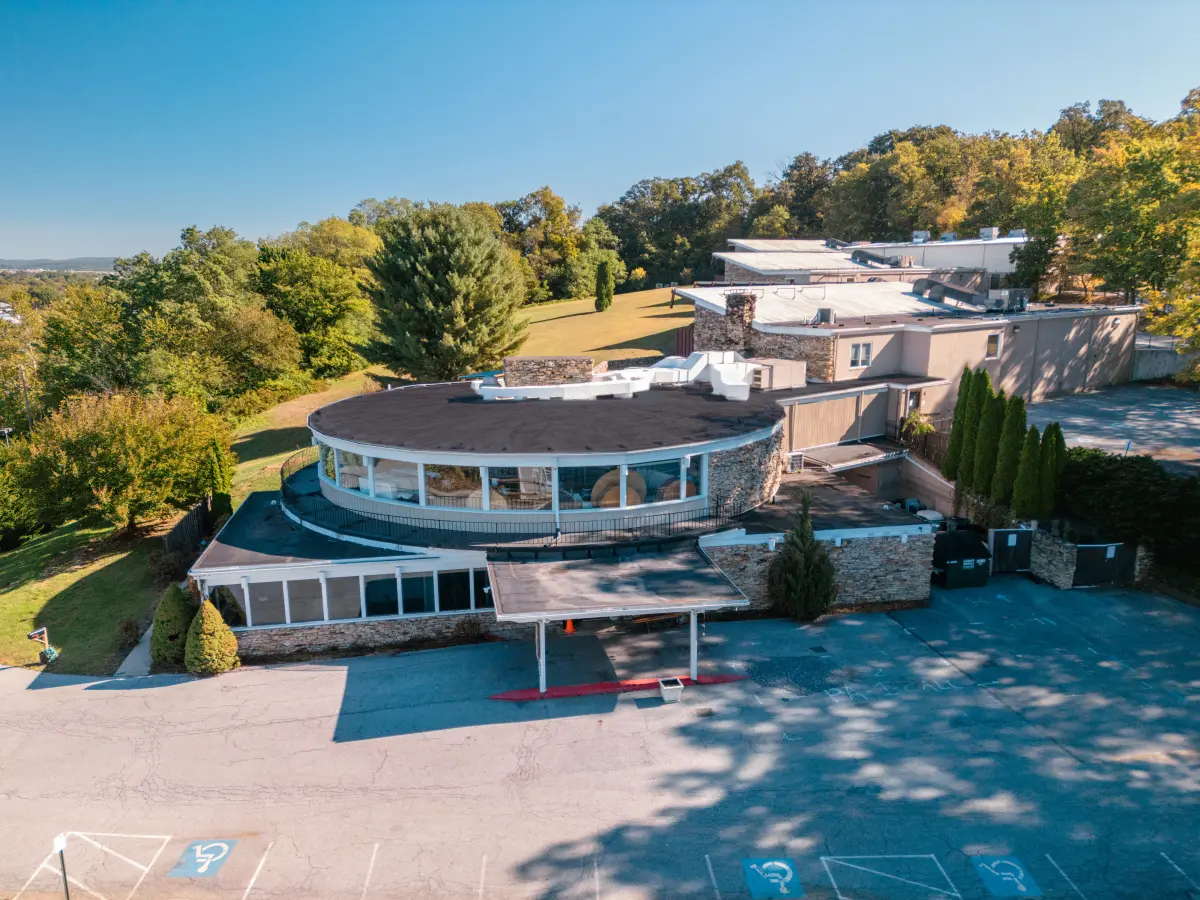 Wide aerial view of a behavioral health treatment campus set among rolling hills.