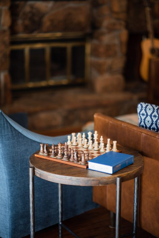Chessboard setup on small table in cozy lounge