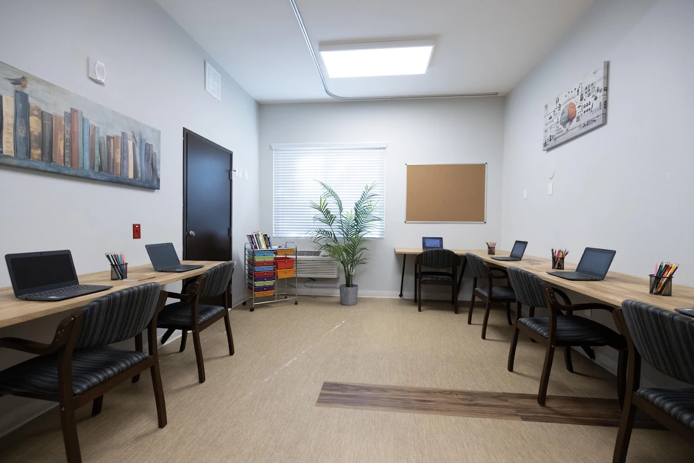Classroom with desks, laptops, and wall art