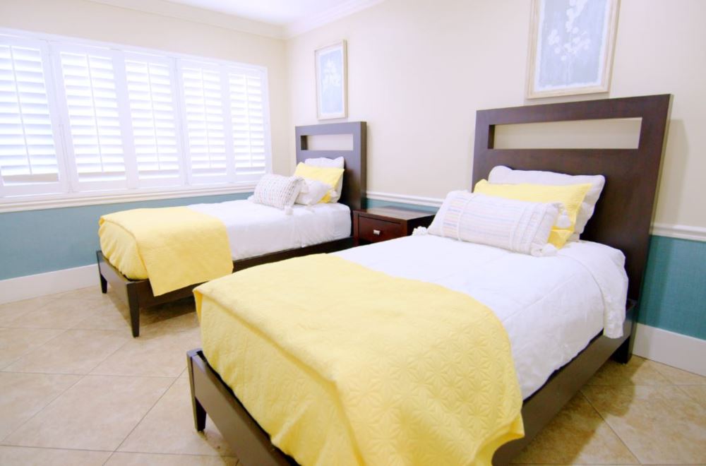 Bright twin bedroom with yellow bedding and wood furniture