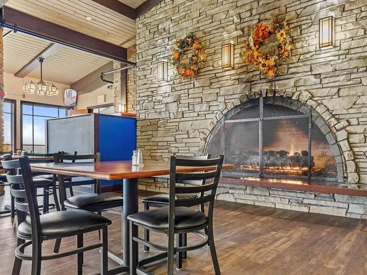 Stone fireplace with dining tables and chairs nearby