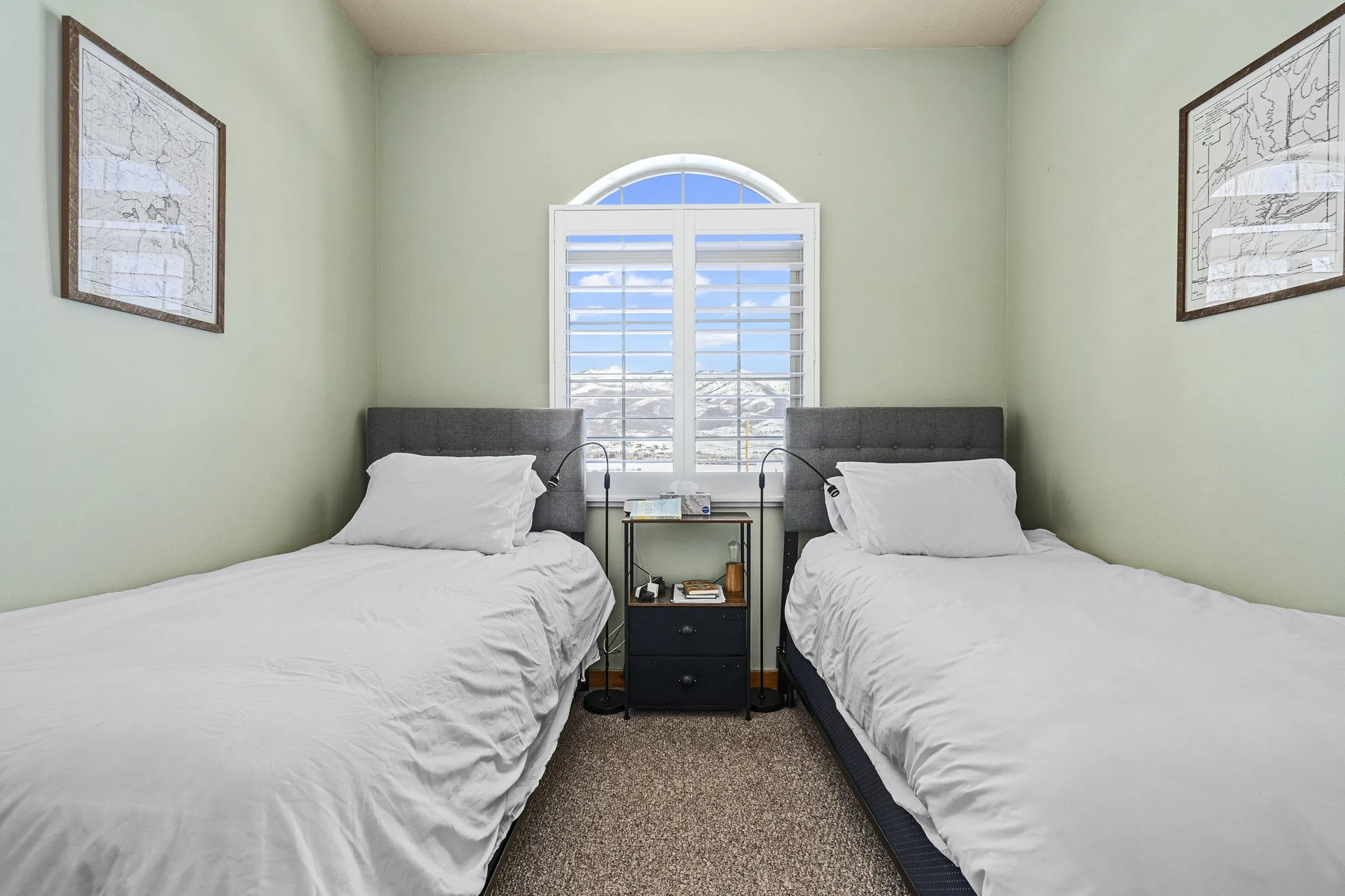 Twin beds with mountain views from arched window
