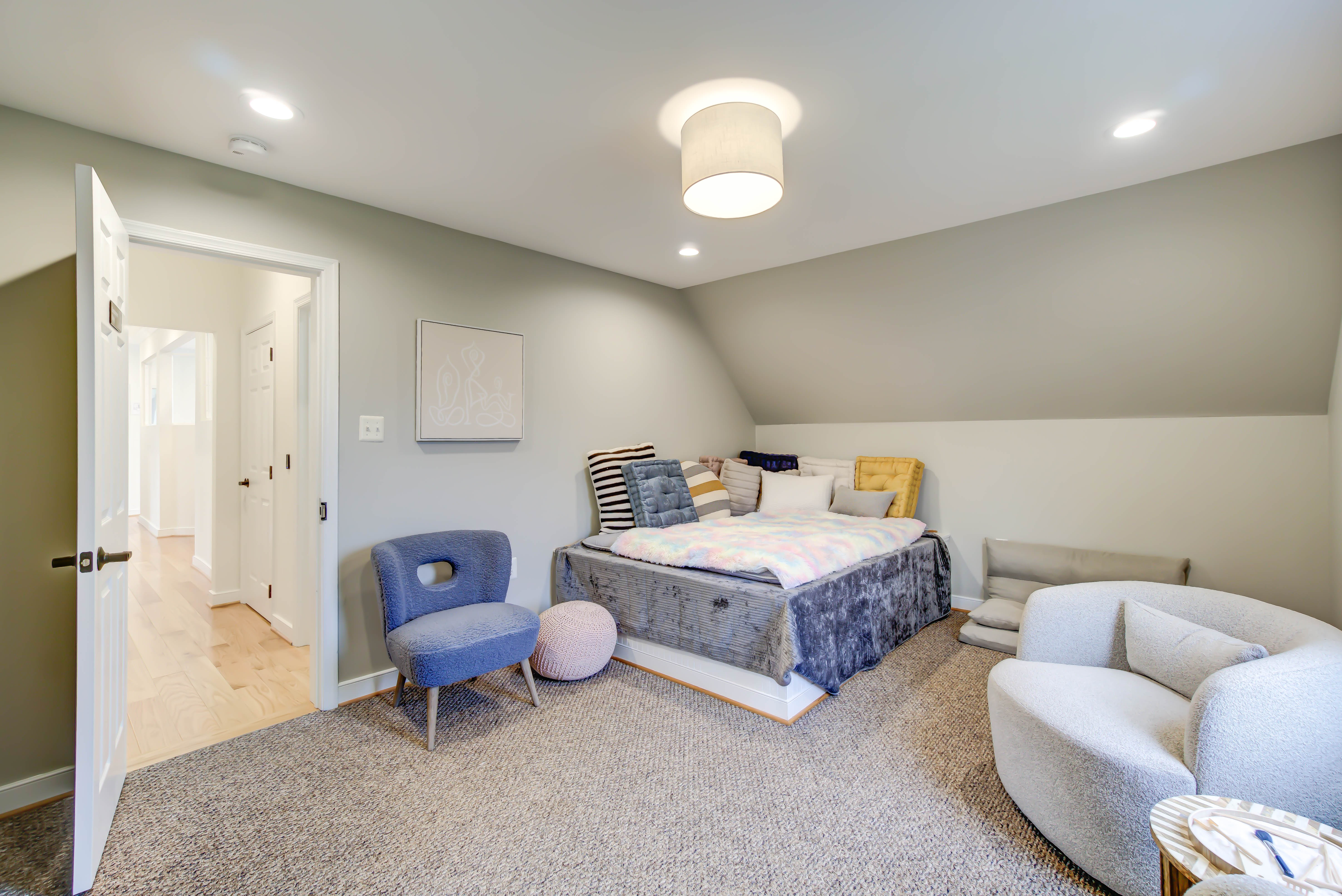 Soft-toned bedroom with armchairs and layered bedding