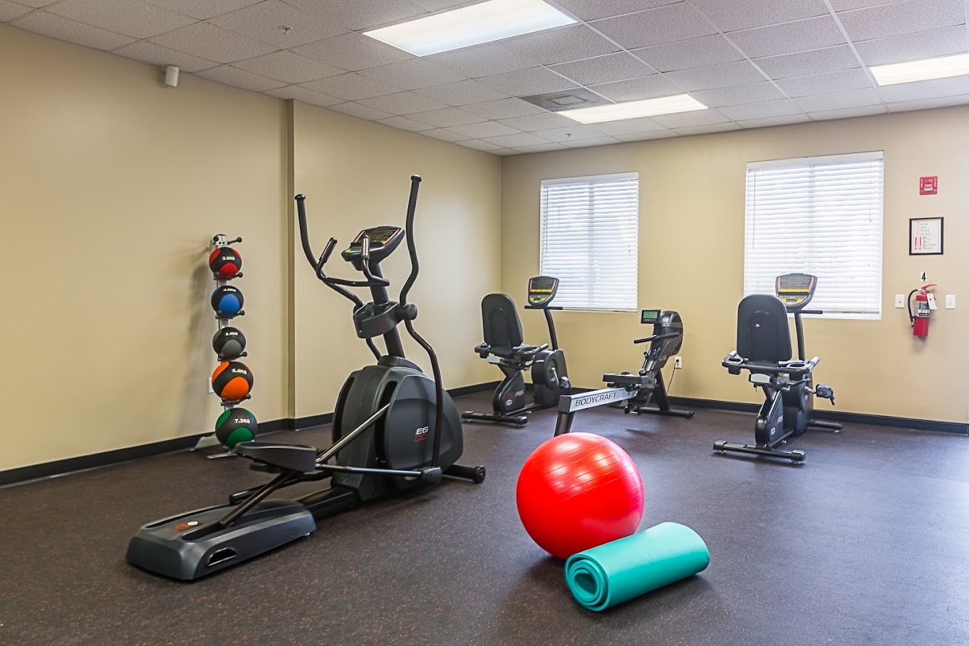 Fitness room with exercise bikes, elliptical, and workout equipment.