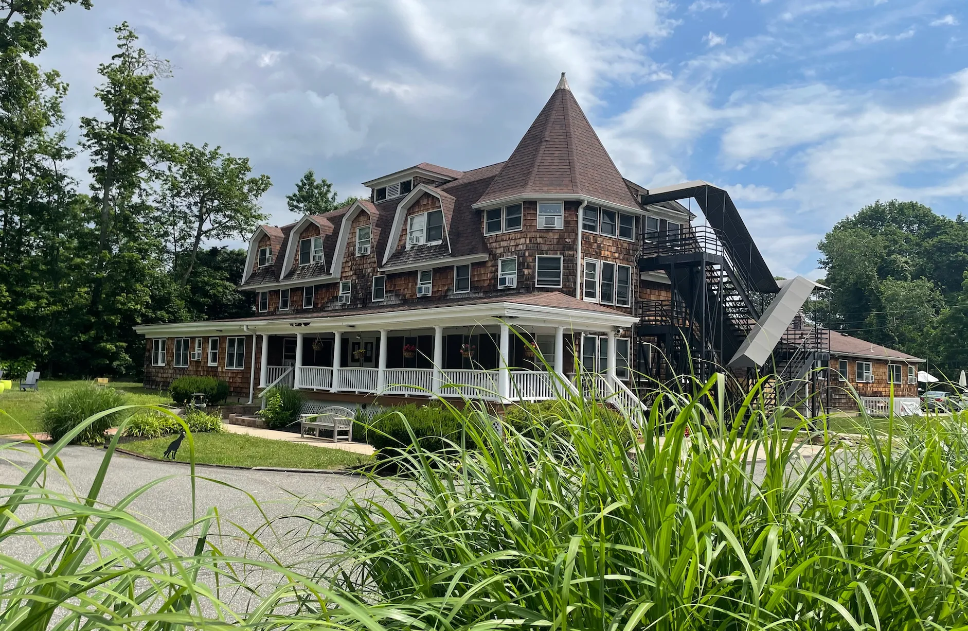 Rustic rehab facility with wraparound porch and tall turret