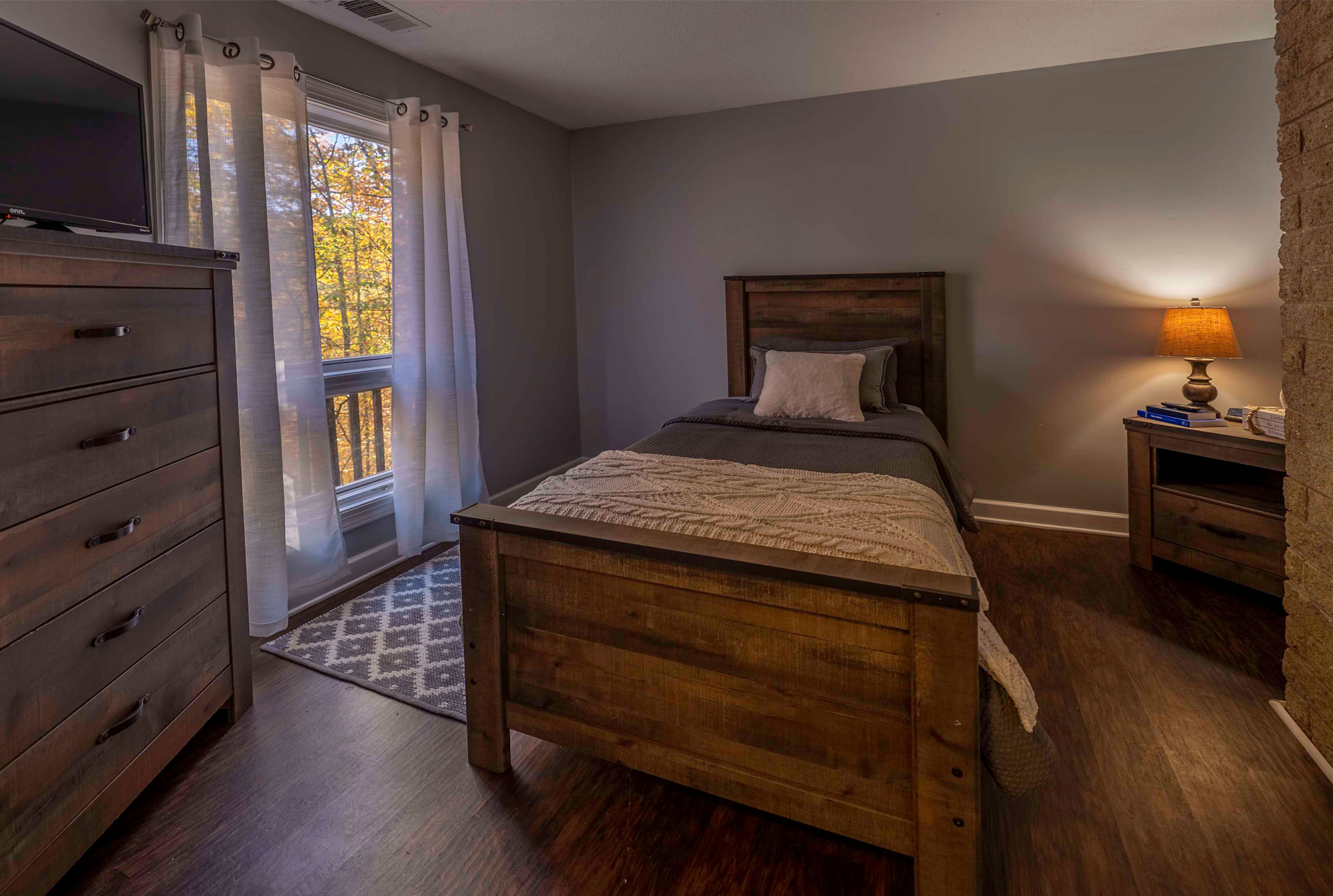 A cozy bedroom with a wooden bed frame and warm lighting