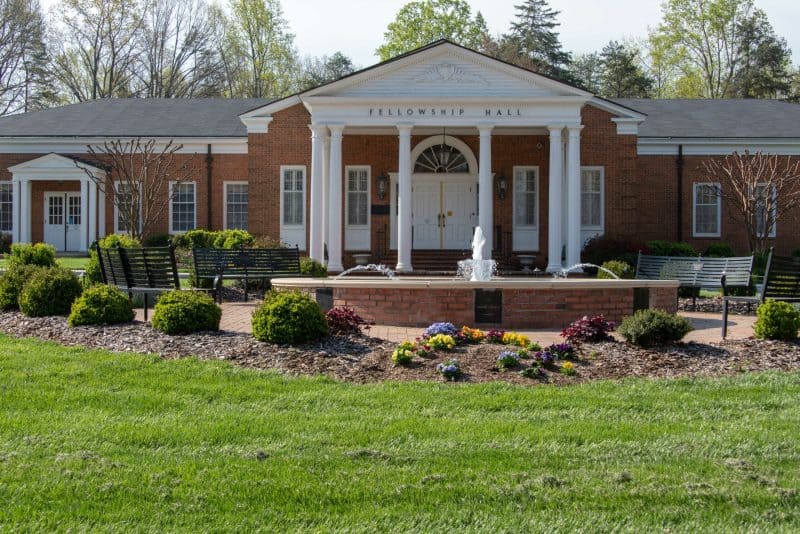 Brick building entrance with fountain and white pillars