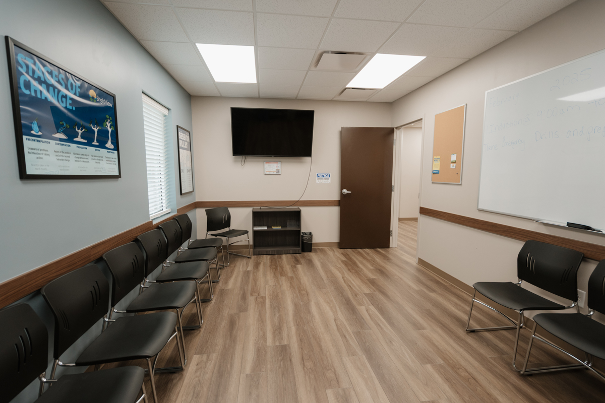 Group room with rows of chairs, whiteboard, and television