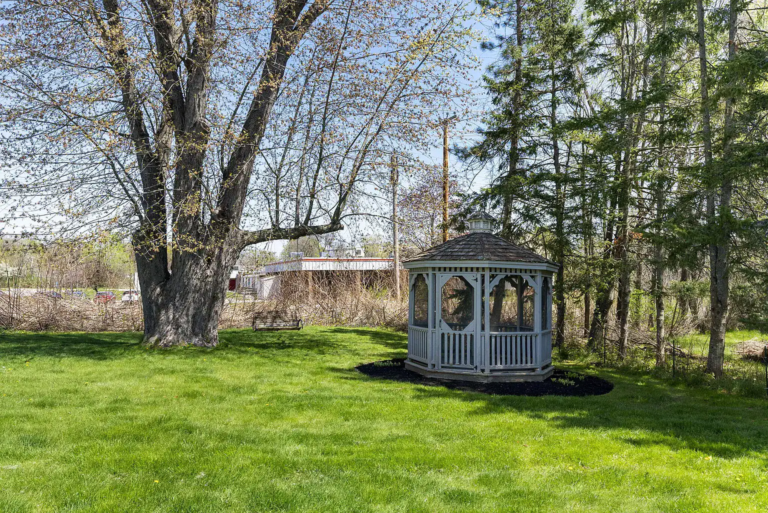 Peaceful gazebo surrounded by mature trees and landscaped grounds at Southern Maine Recovery