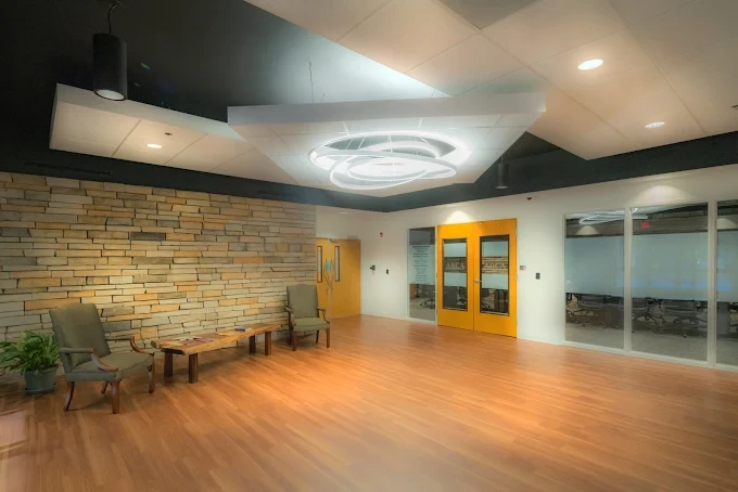 Lounge with modern light fixture and stone accent wall