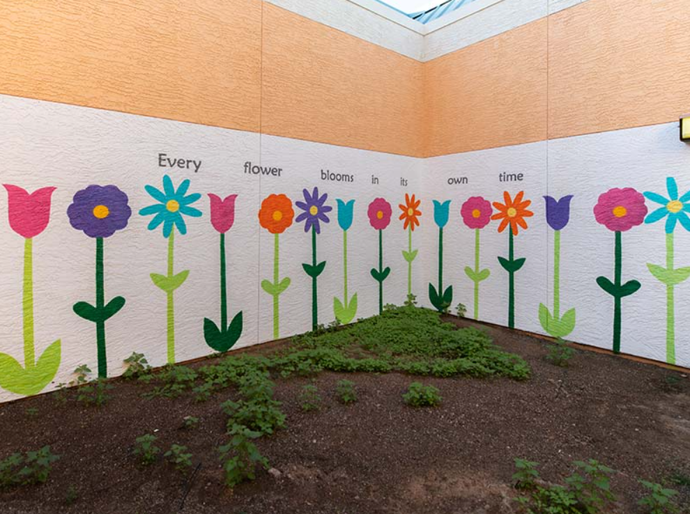Courtyard mural with colorful flowers and inspirational quote