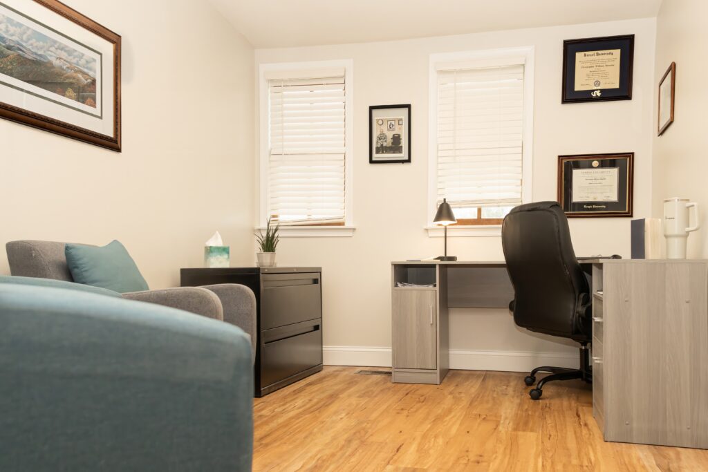 Desk, chair, and framed diplomas in quiet office
