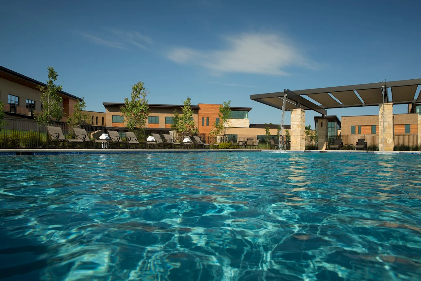 Outdoor pool with lounge chairs and water features for relaxation