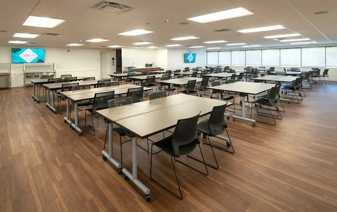 Large room with rows of tables and flat-screen monitors