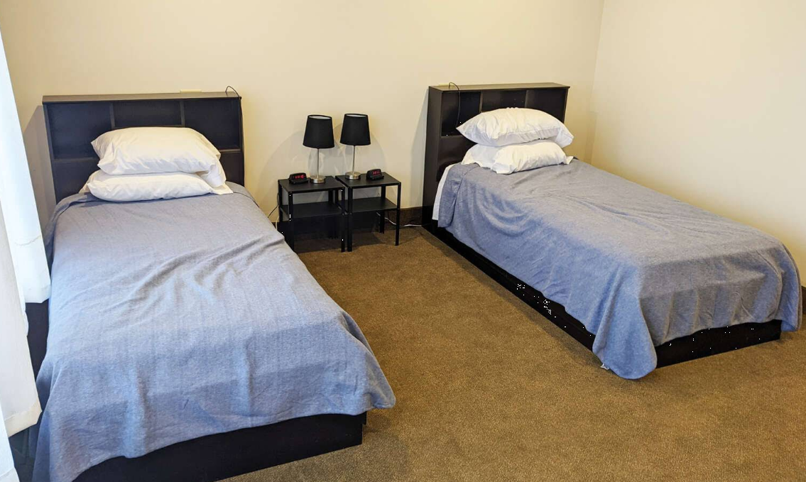 Shared bedroom with two twin beds and nightstands at recovery center