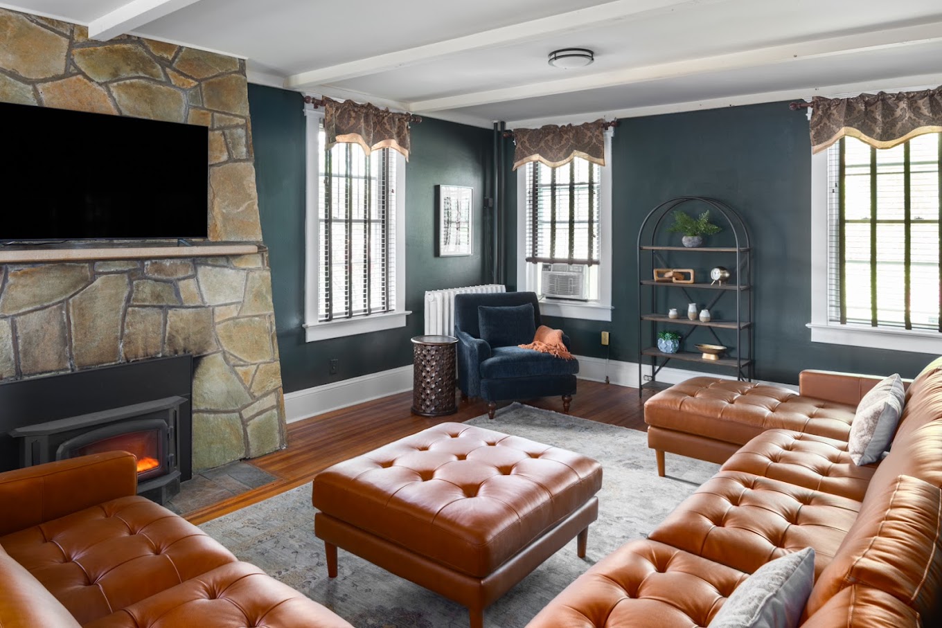 Lounge with a stone fireplace, seating, and windows.