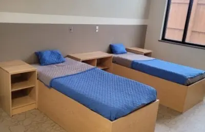 Two twin beds with blue bedding in a shared hospital room