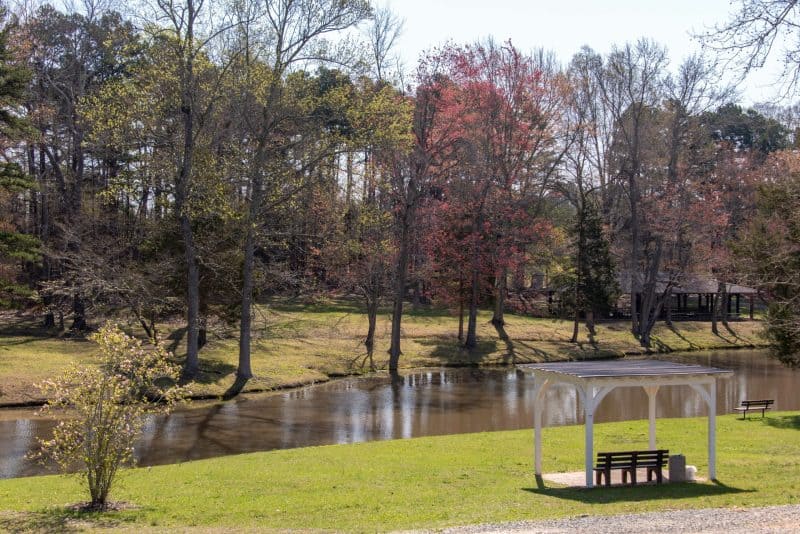 Small pavilion by a lake surrounded by trees