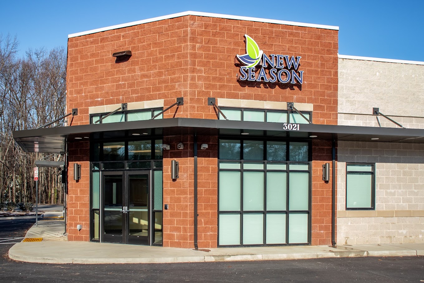 Modern brick facility with New Season logo and glass entrance