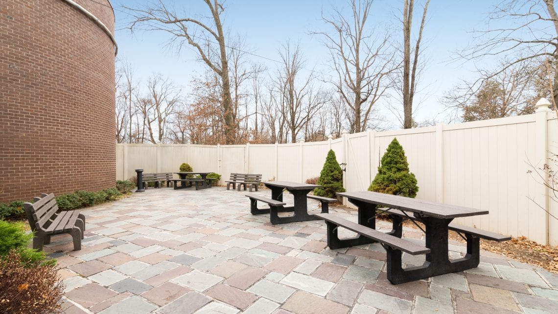 Gated patio with benches and picnic tables