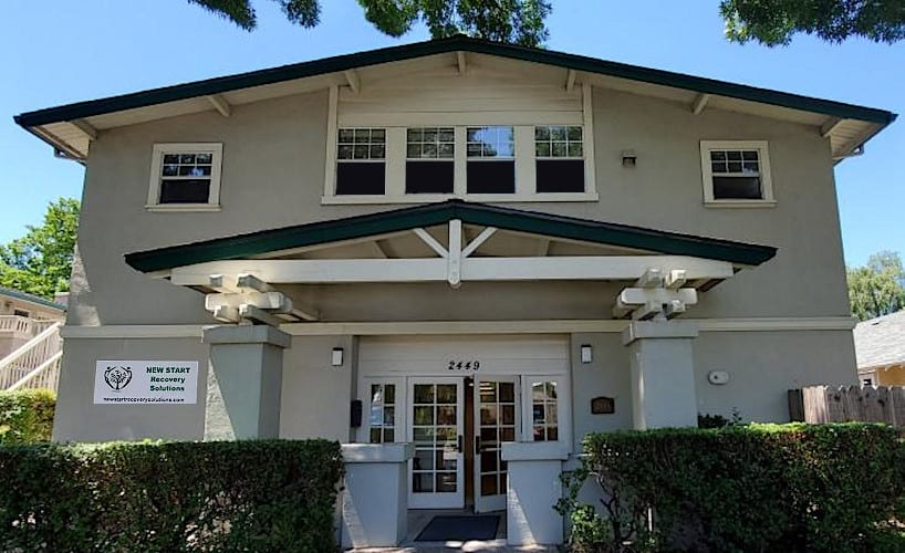 Two-story tan building with green trim and entryway