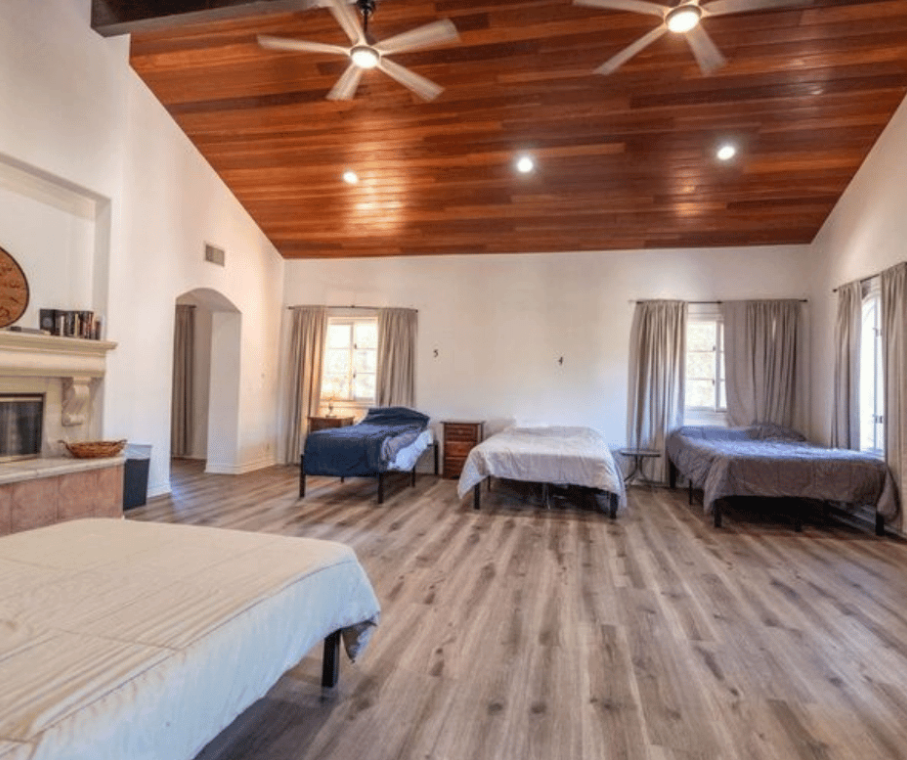 Large shared bedroom with multiple beds and high ceilings