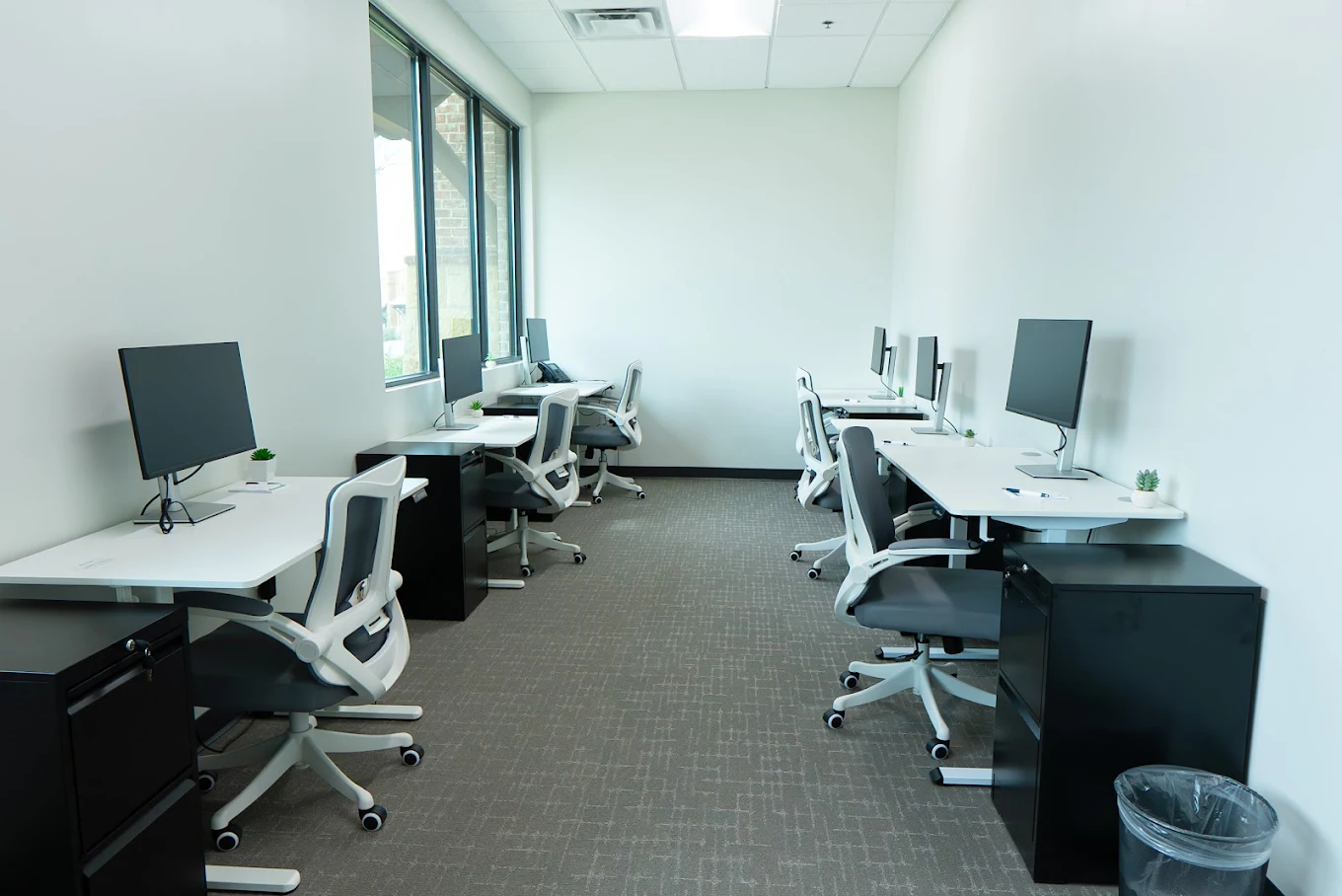 Office desks with computers by windows